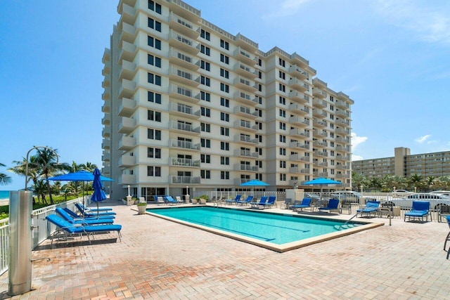 pool with a patio and fence