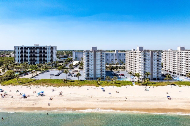 drone / aerial view featuring a view of city, a beach view, and a water view