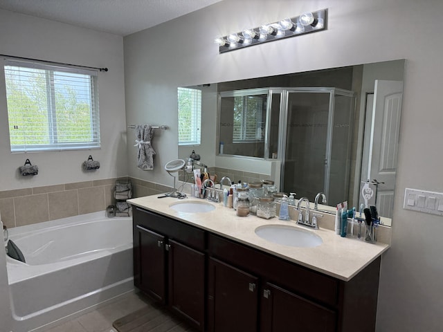 full bath with a garden tub, a shower stall, plenty of natural light, and a sink