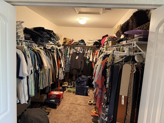 spacious closet with attic access and carpet flooring