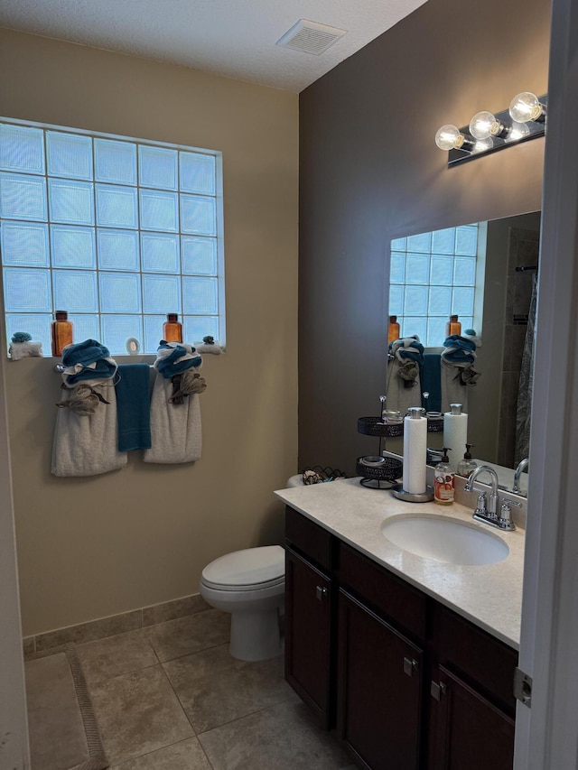 full bathroom with baseboards, visible vents, toilet, tile patterned floors, and vanity