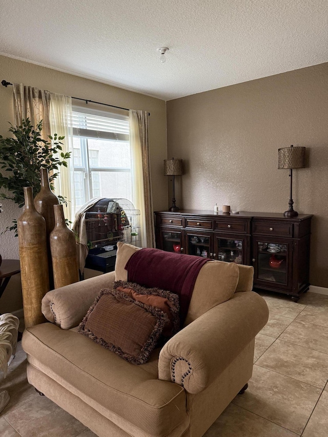 living area with a textured wall, a textured ceiling, and tile patterned floors