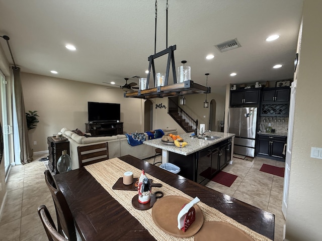 dining area featuring light tile patterned floors, visible vents, arched walkways, and recessed lighting