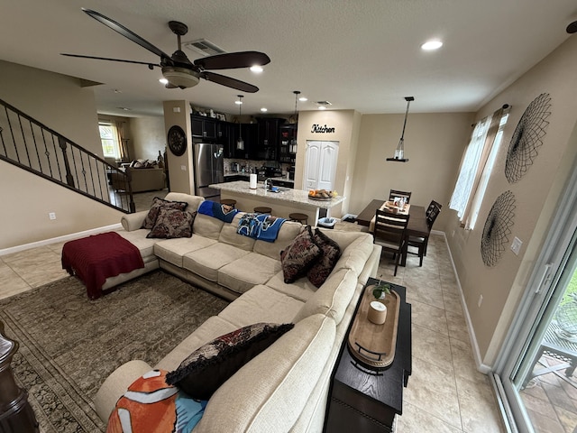 living area with light tile patterned floors, recessed lighting, visible vents, baseboards, and stairs