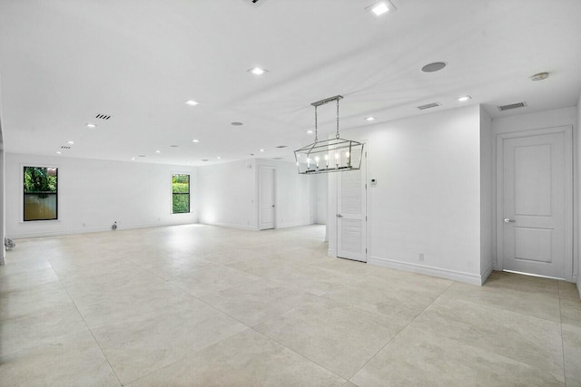 unfurnished living room with visible vents, recessed lighting, and baseboards