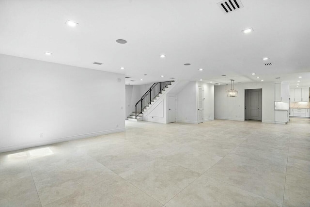 unfurnished living room with recessed lighting, visible vents, baseboards, and stairway