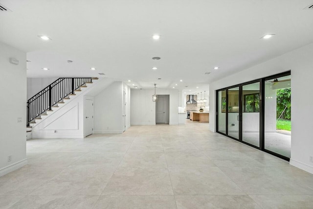 unfurnished living room featuring stairway, recessed lighting, visible vents, and baseboards