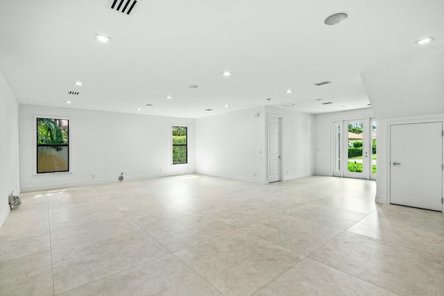 spare room featuring visible vents, recessed lighting, and baseboards