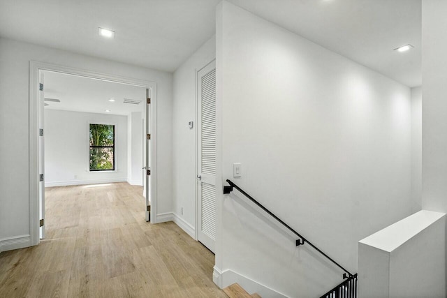 corridor featuring light wood-style flooring, recessed lighting, an upstairs landing, and baseboards