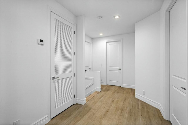 hall featuring recessed lighting, baseboards, and wood finished floors