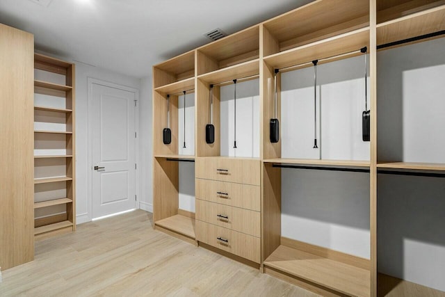 spacious closet featuring light wood-type flooring and visible vents