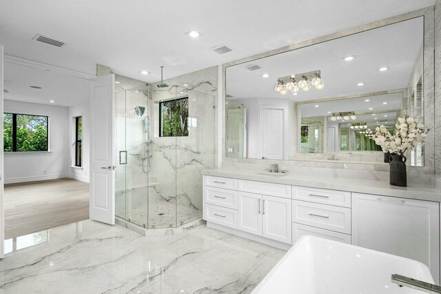 full bath featuring vanity, visible vents, a marble finish shower, a freestanding tub, and marble finish floor