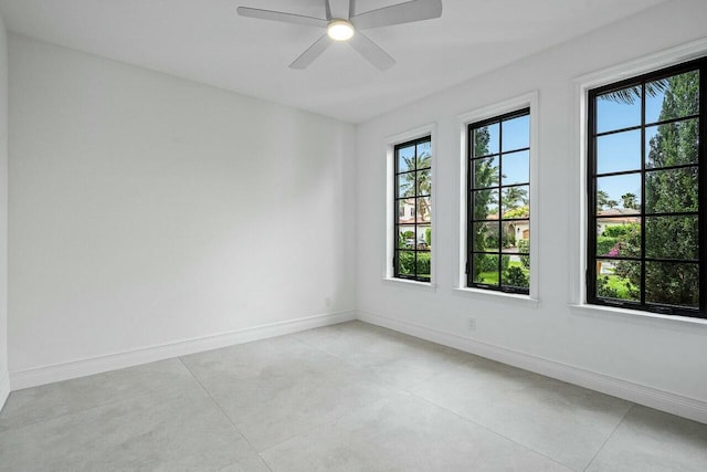 unfurnished room with a ceiling fan and baseboards