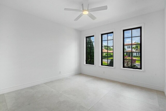 unfurnished room with baseboards and a ceiling fan