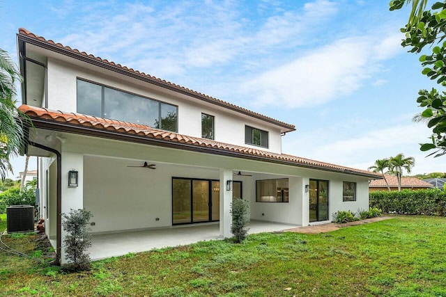 back of house with cooling unit, a yard, ceiling fan, stucco siding, and a patio area