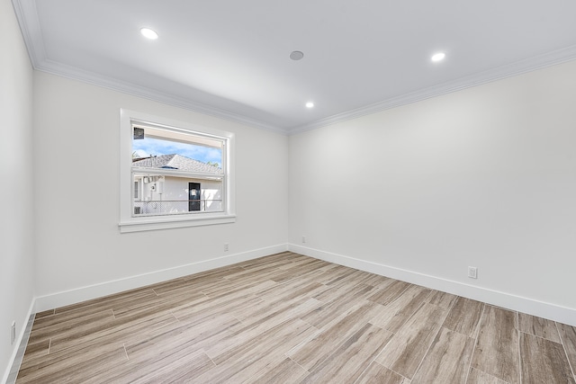 spare room with light wood finished floors, baseboards, and ornamental molding