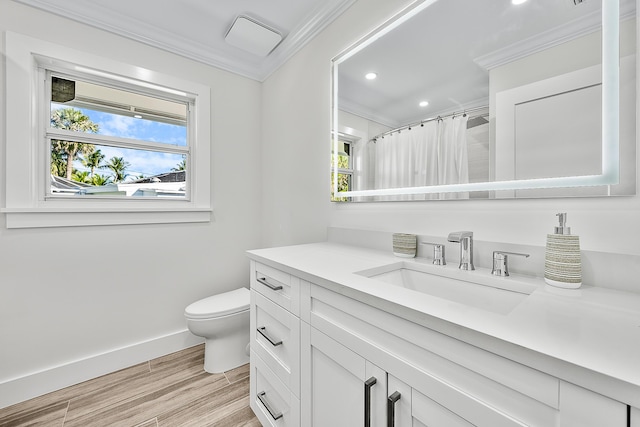 bathroom featuring a wealth of natural light, crown molding, and wood finished floors