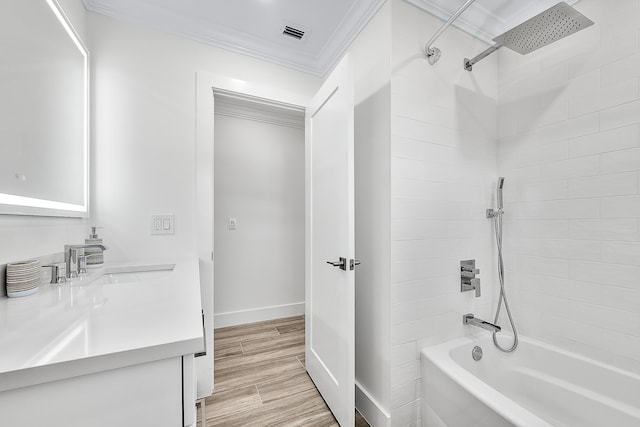 full bathroom featuring shower / washtub combination, visible vents, ornamental molding, vanity, and wood finished floors