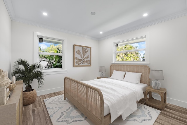 bedroom with recessed lighting, crown molding, baseboards, and wood finished floors