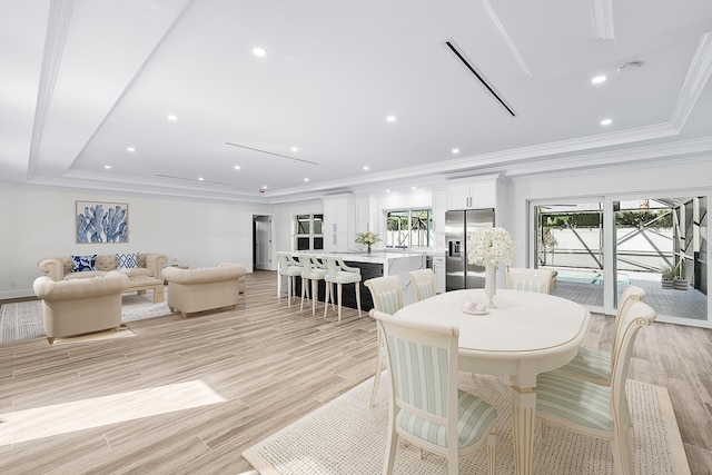 dining space featuring a healthy amount of sunlight, light wood finished floors, ornamental molding, and recessed lighting