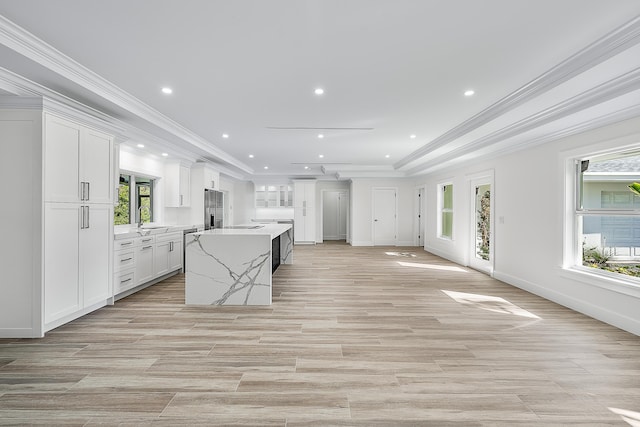 kitchen featuring recessed lighting, white cabinetry, open floor plan, and a center island