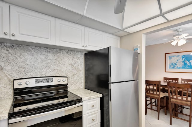 kitchen featuring light tile patterned floors, decorative backsplash, a ceiling fan, stainless steel appliances, and light countertops