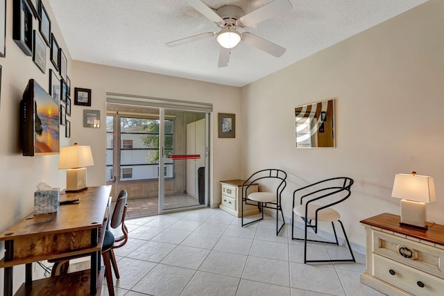 office area with a ceiling fan, light tile patterned flooring, and a textured ceiling