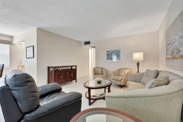 living area featuring light tile patterned floors, a textured ceiling, and visible vents