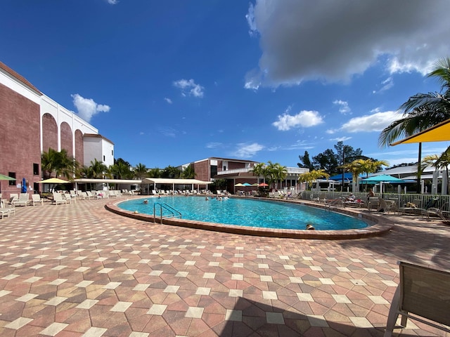 community pool with fence and a patio