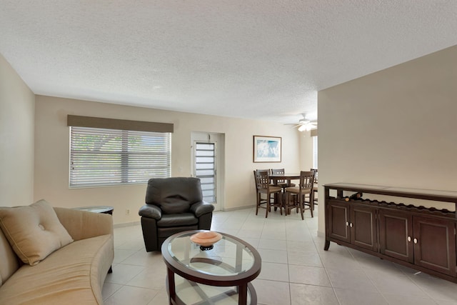 living room with light tile patterned floors, a textured ceiling, and a wealth of natural light