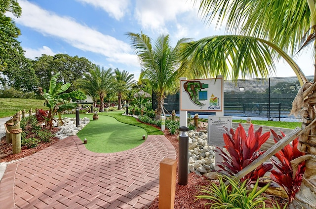 surrounding community featuring a tennis court and fence