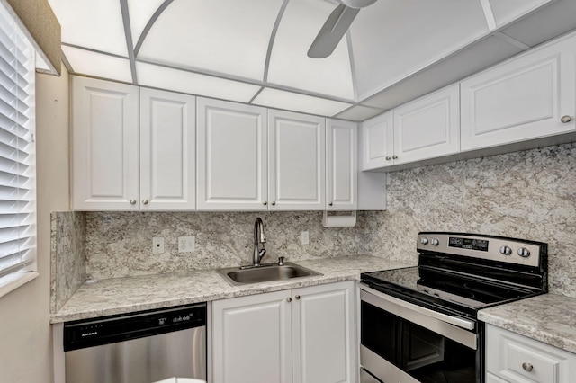 kitchen featuring backsplash, appliances with stainless steel finishes, white cabinets, and a sink