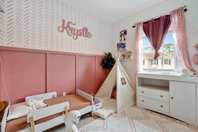 bedroom with a wainscoted wall and a decorative wall