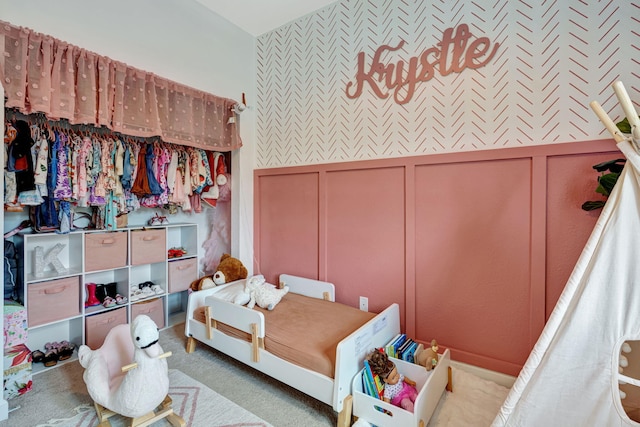 carpeted bedroom with a decorative wall