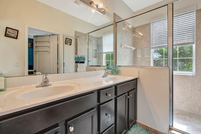 bathroom with double vanity, visible vents, a sink, and a shower with shower door