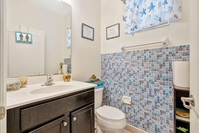 half bathroom with toilet, vanity, and tile walls