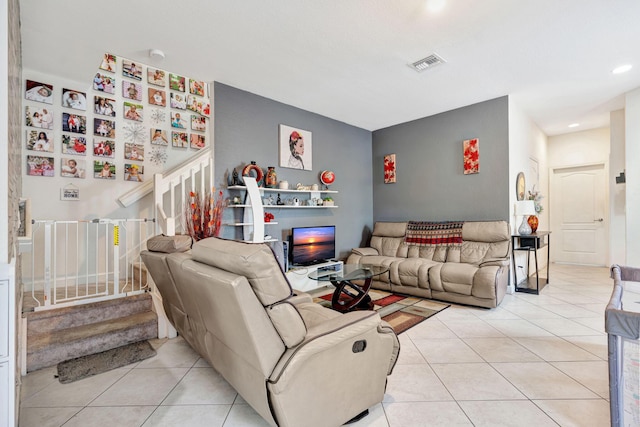 living room with light tile patterned floors, stairway, and visible vents