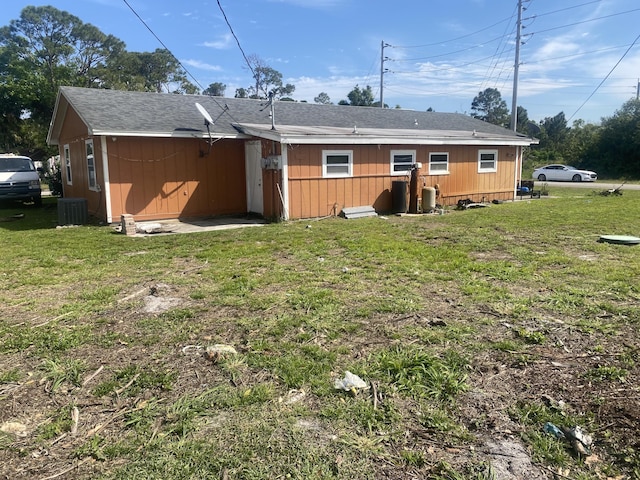 back of property with a lawn and cooling unit