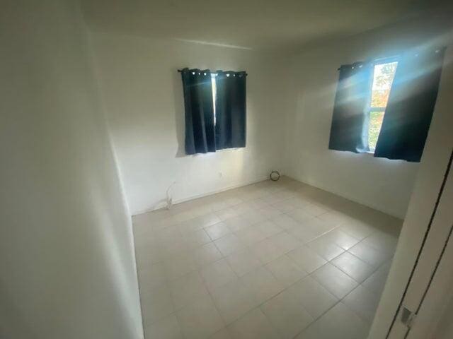 unfurnished room featuring light tile patterned flooring