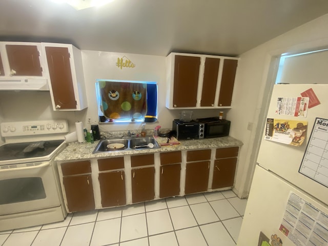 kitchen with white appliances, light tile patterned floors, light countertops, under cabinet range hood, and a sink