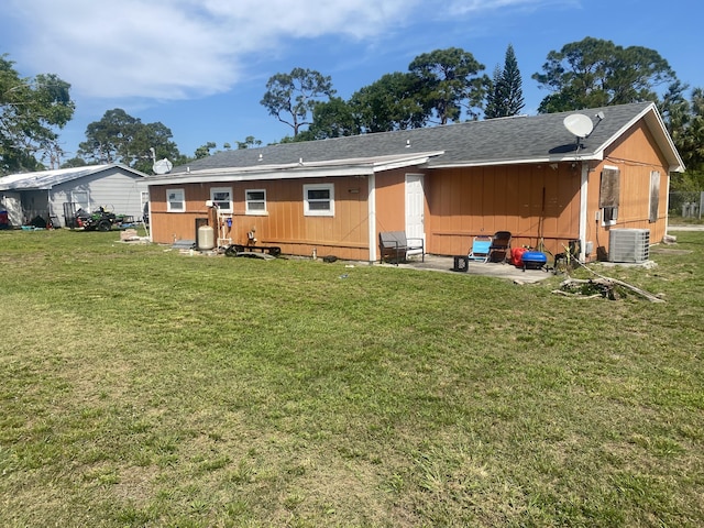 back of house featuring central AC unit and a yard