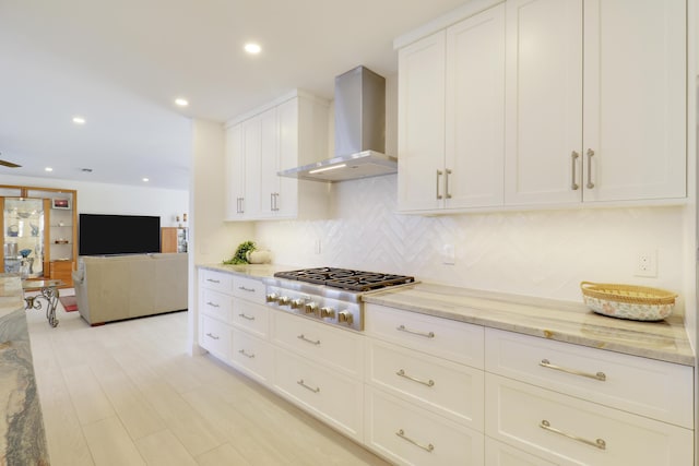 8579 SE Sabal St, Hobe Sound, FL 33455 - kitchen featuring wall chimney range hood, stainless steel gas stovetop, light stone countertops, decorative backsplash, and recessed lighting