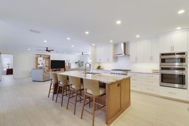 8579 SE Sabal St, Hobe Sound, FL 33455 - kitchen featuring wall chimney range hood, a sink, appliances with stainless steel finishes, plenty of natural light, and recessed lighting