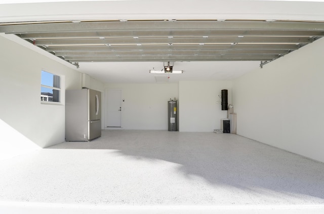 8579 SE Sabal St, Hobe Sound, FL 33455 - garage featuring freestanding refrigerator, water heater, a central vacuum unit, and a garage door opener