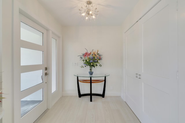 8579 SE Sabal St, Hobe Sound, FL 33455 - foyer with a chandelier, light wood-type flooring, and baseboards