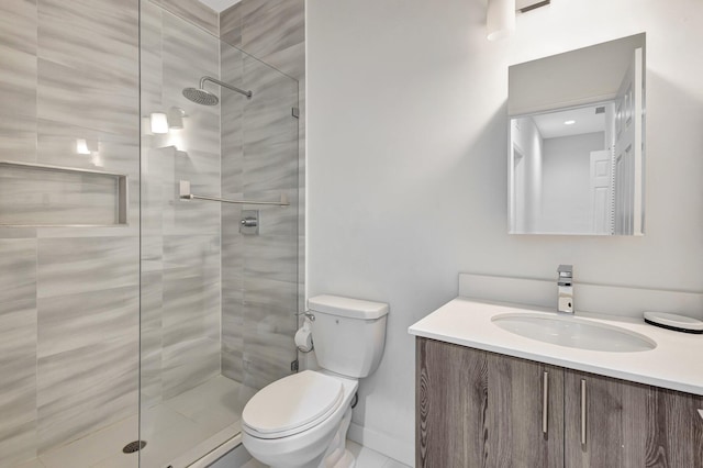 full bathroom with vanity, toilet, and a tile shower