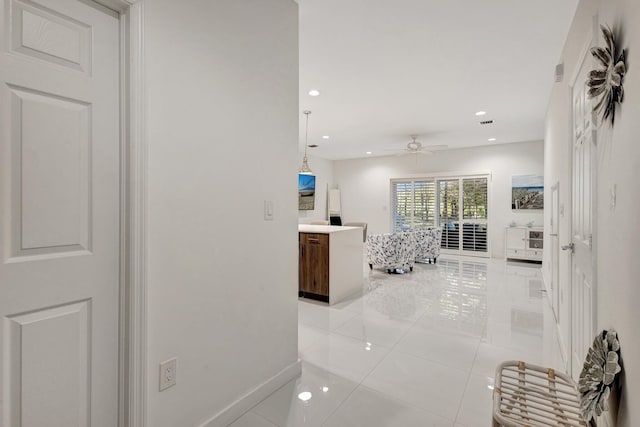 corridor featuring light tile patterned flooring, recessed lighting, and baseboards