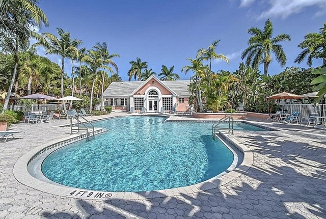 pool with a patio area and fence