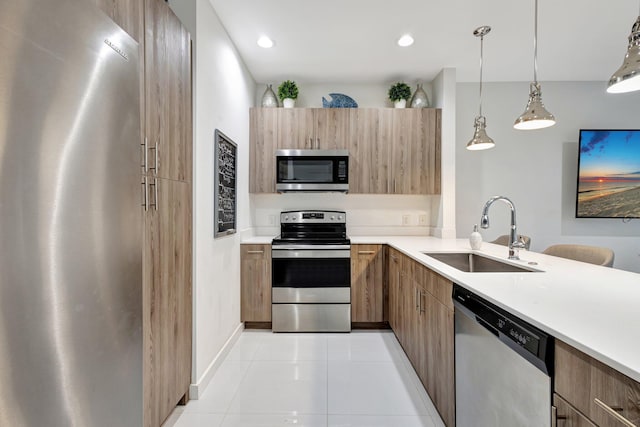 kitchen with stainless steel appliances, modern cabinets, light countertops, and a sink