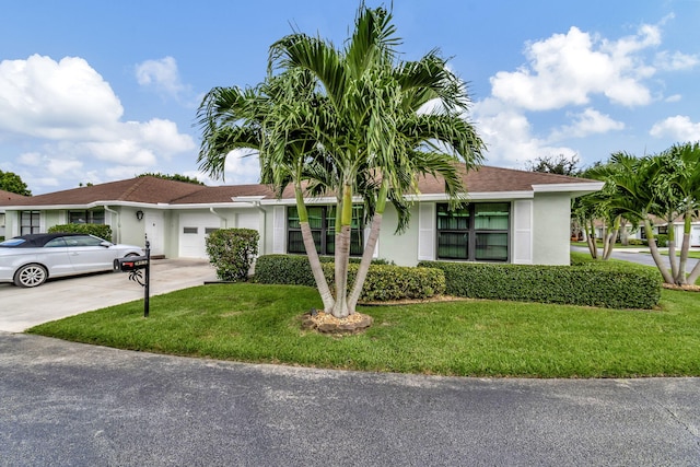 single story home with a garage, driveway, a front lawn, and stucco siding